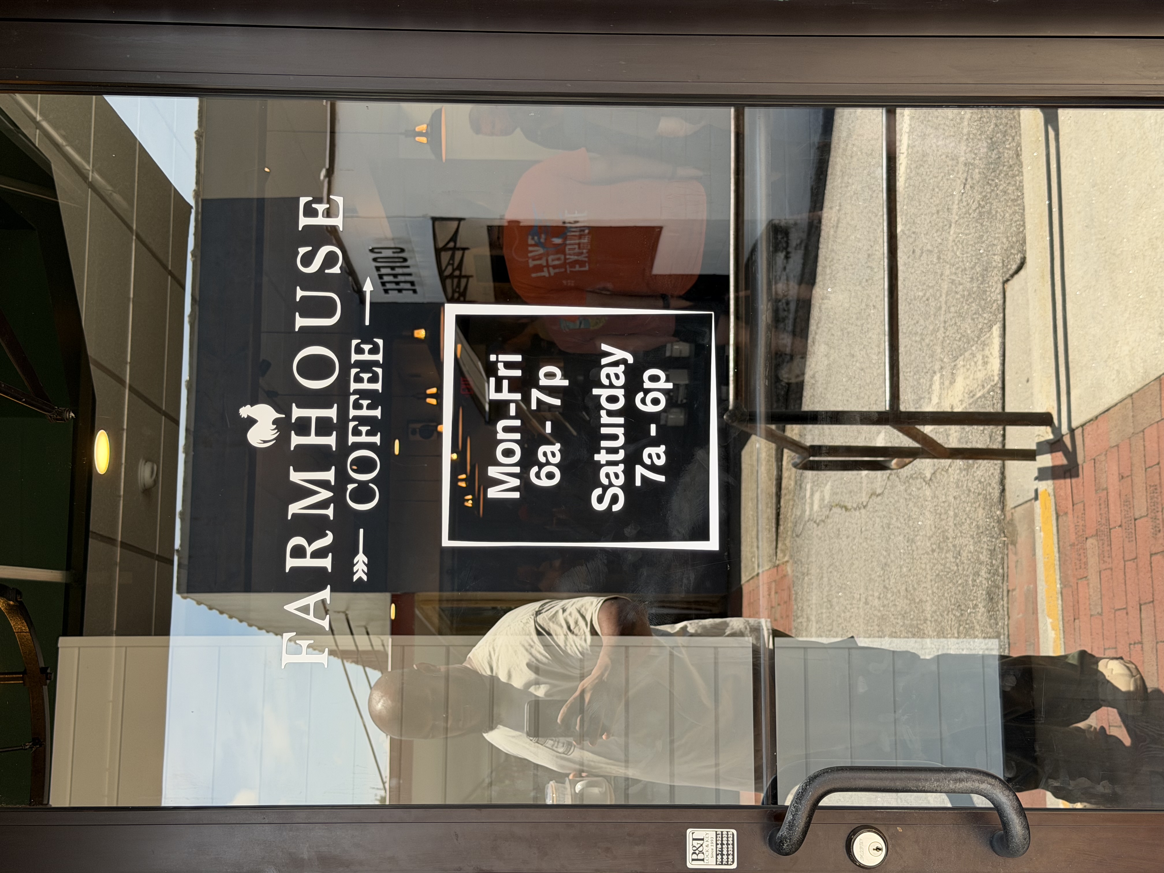 Farmhouse Coffee exterior building sign - large white sign with black lettering on brick wall